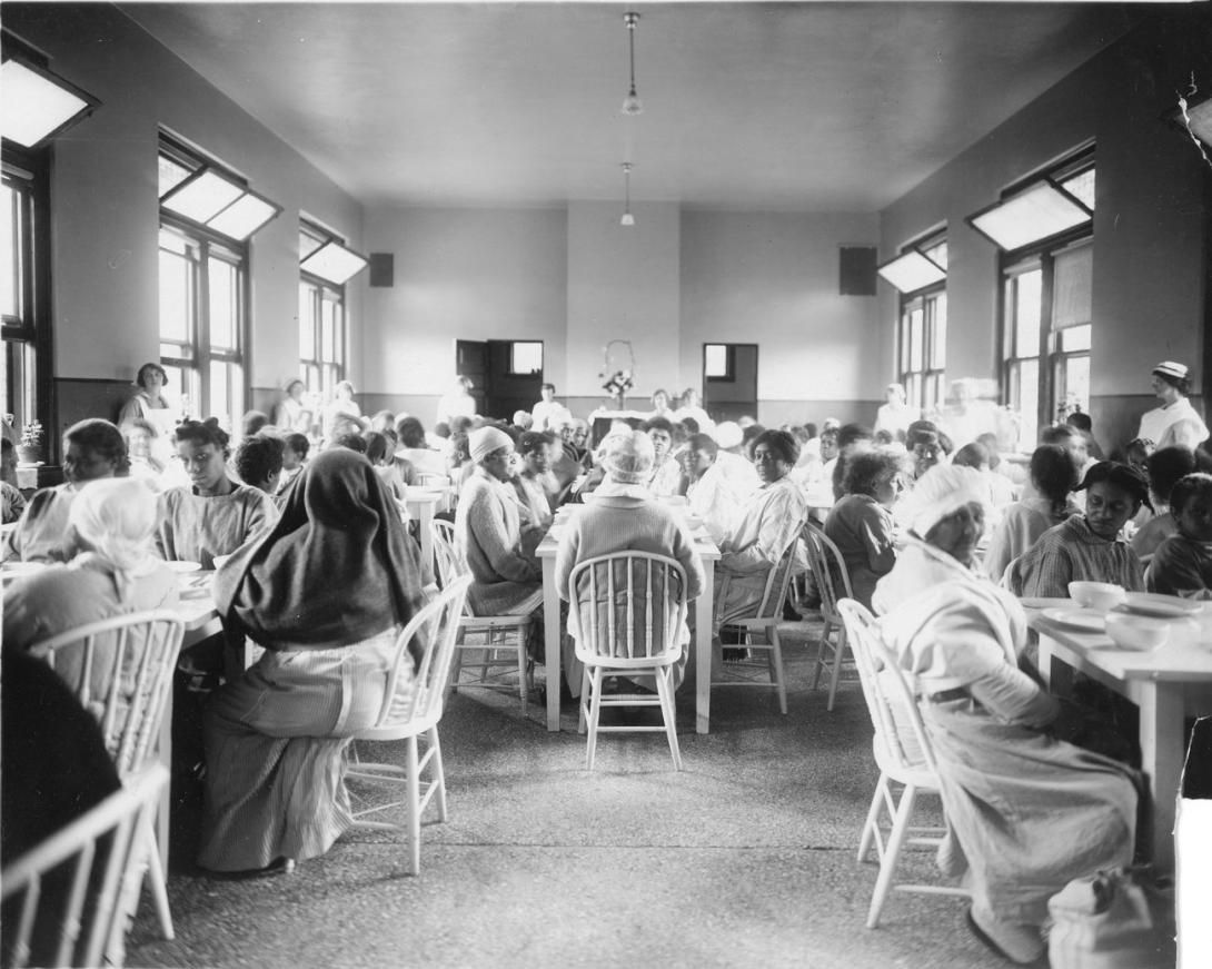 Patients sit in a dining hall in 1915